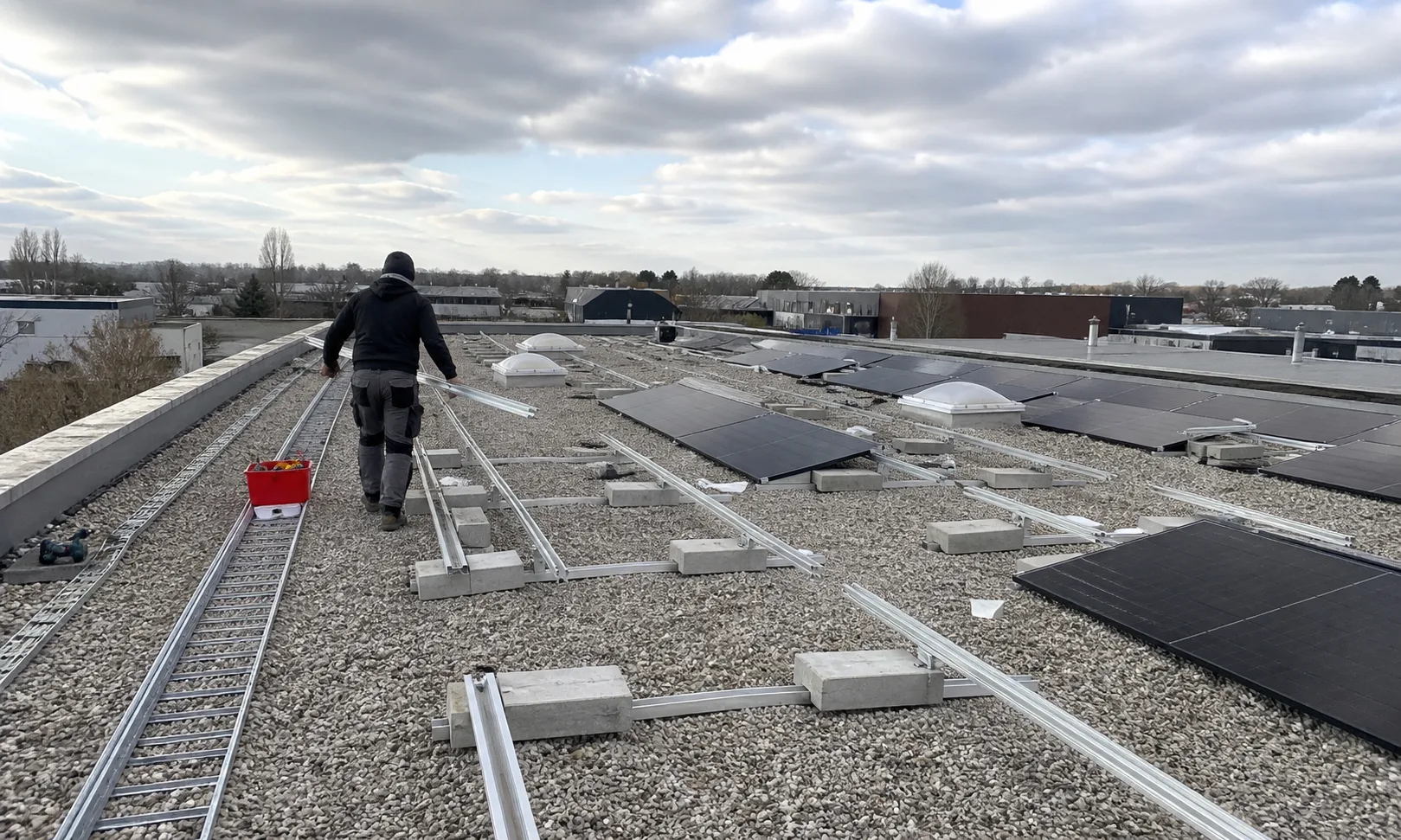 Solarteur bei der Montage einer ballastierten Photovoltaikanlage auf einem Flachdach